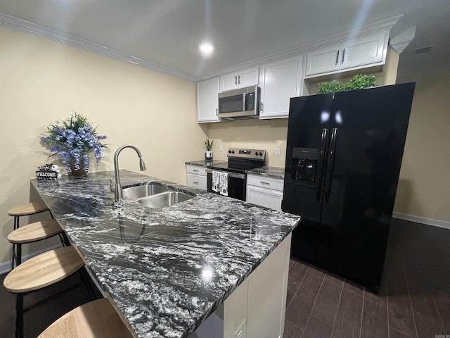 kitchen featuring appliances with stainless steel finishes, sink, dark stone counters, and white cabinets