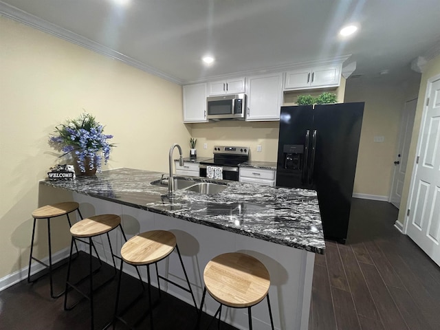 kitchen with stainless steel appliances, white cabinetry, a kitchen bar, and kitchen peninsula