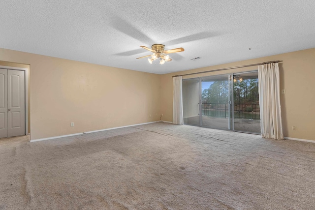 carpeted spare room with a textured ceiling and ceiling fan