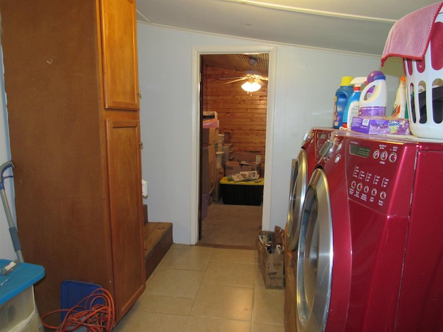 clothes washing area featuring independent washer and dryer, wooden walls, and light tile patterned floors