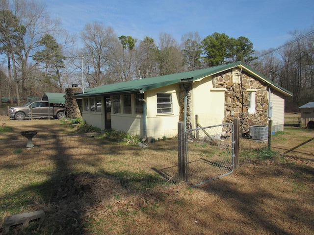 view of side of property with a sunroom and central air condition unit