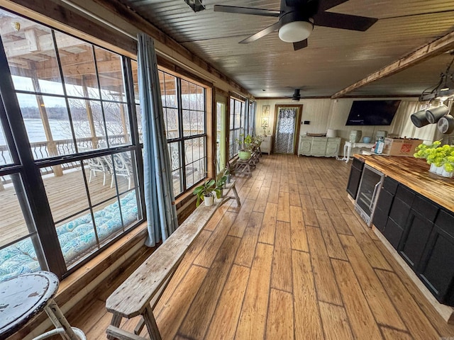 sunroom / solarium with a water view and ceiling fan