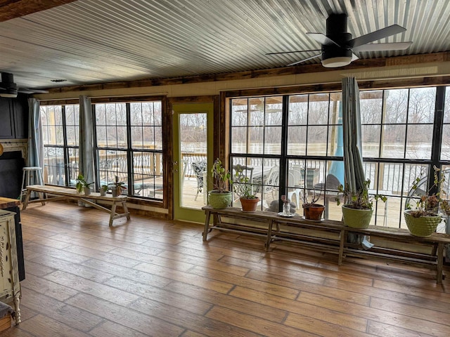 unfurnished sunroom with ceiling fan