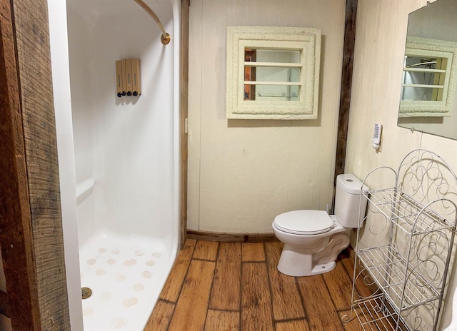 bathroom featuring toilet, hardwood / wood-style floors, and a shower