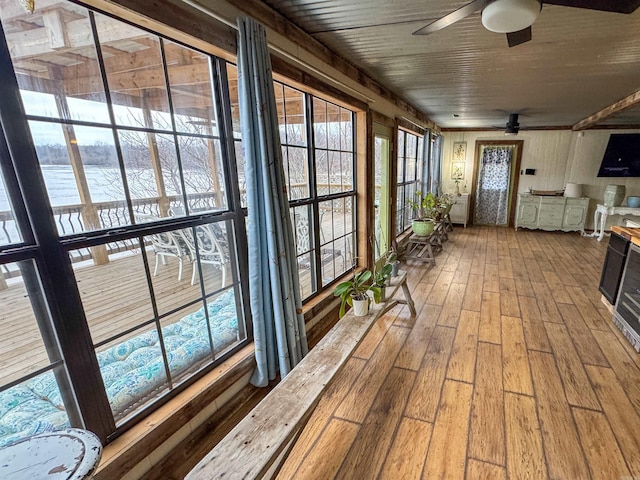 sunroom featuring wood ceiling and ceiling fan