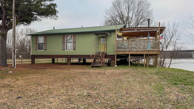 manufactured / mobile home with a water view and a front lawn