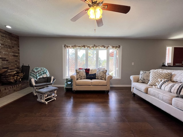 living room with dark hardwood / wood-style flooring, ceiling fan, and a textured ceiling