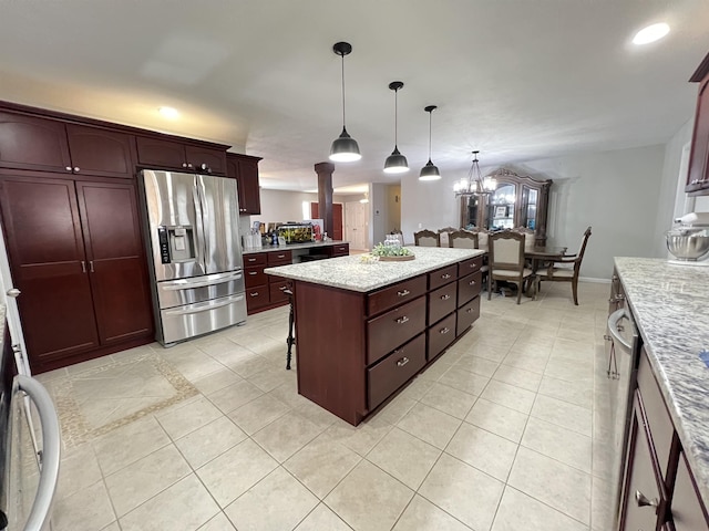 kitchen with hanging light fixtures, a center island, light tile patterned floors, light stone counters, and stainless steel refrigerator with ice dispenser