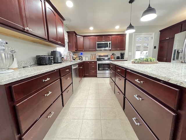 kitchen with pendant lighting, sink, light tile patterned floors, light stone counters, and stainless steel appliances