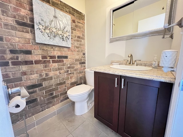 bathroom with vanity, brick wall, tile patterned floors, and toilet