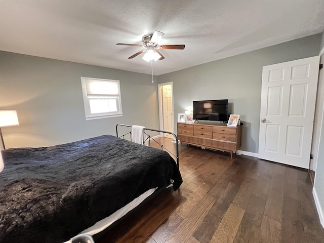 bedroom featuring dark hardwood / wood-style flooring, ceiling fan, and a textured ceiling