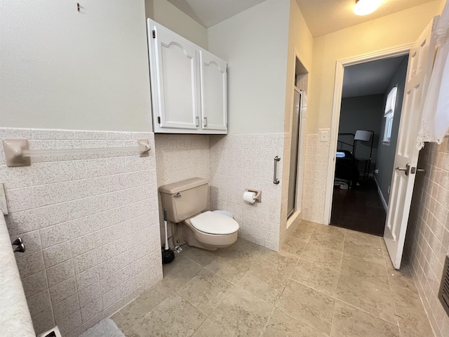 bathroom with walk in shower, toilet, and tile walls