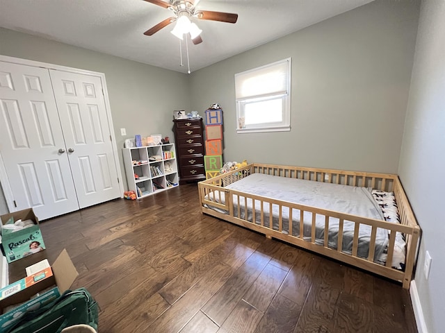 bedroom with dark wood-type flooring, ceiling fan, and a closet