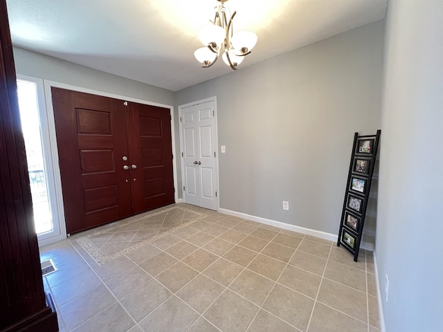 foyer entrance with light tile patterned floors and a notable chandelier