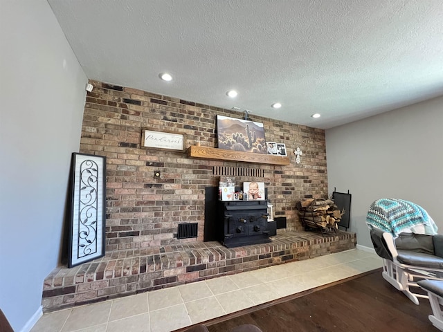 living room with hardwood / wood-style flooring, brick wall, and a textured ceiling