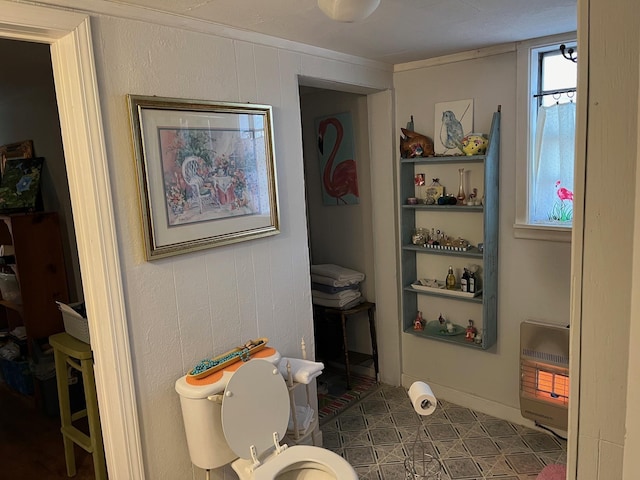 bathroom featuring heating unit and toilet