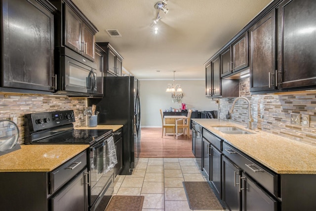 kitchen featuring light tile patterned flooring, sink, hanging light fixtures, black appliances, and light stone countertops