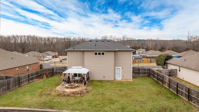 back of property featuring a gazebo, a yard, and a fire pit