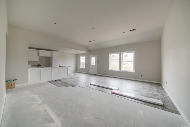 unfurnished living room featuring lofted ceiling