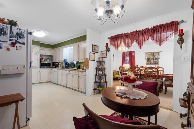 dining area with ornamental molding and a chandelier