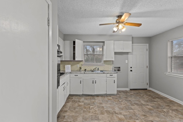 7305 Kentucky Ave, Little Rock, AR 72207 - kitchen with ceiling fan, sink, decorative backsplash, and white cabinets