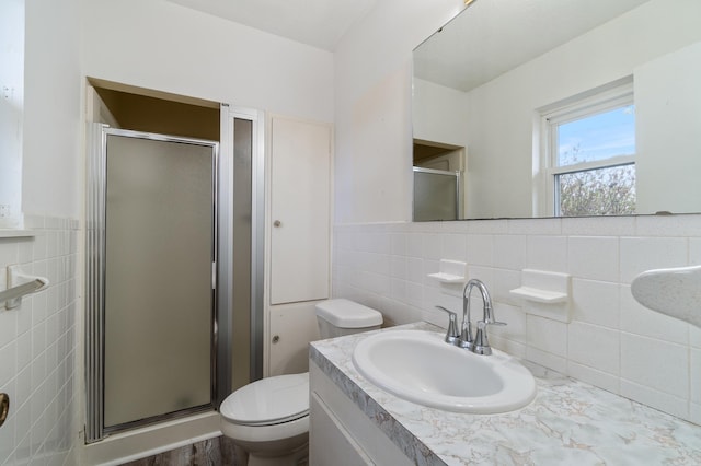 bathroom featuring walk in shower, vanity, toilet, and tile walls