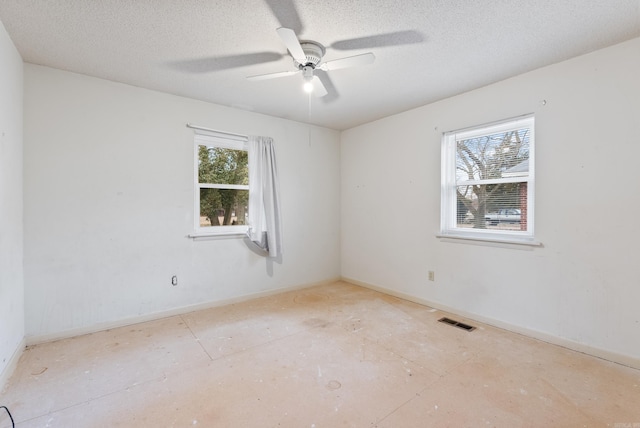 empty room featuring ceiling fan and a textured ceiling