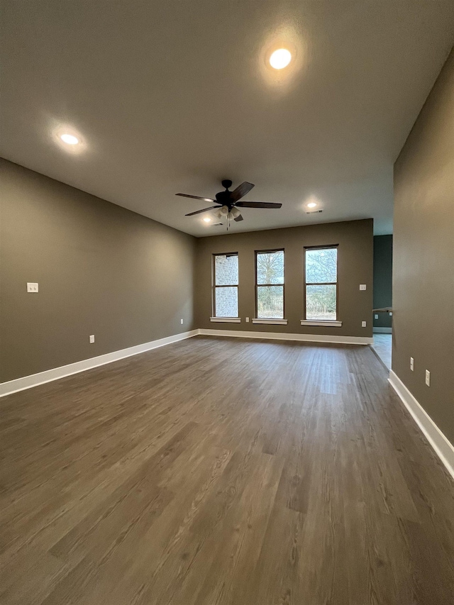 unfurnished living room with dark wood-type flooring and ceiling fan