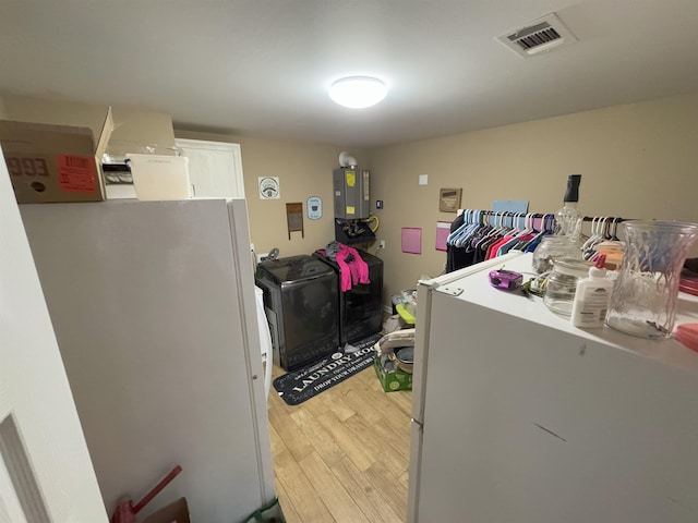 laundry area featuring water heater and wood-type flooring