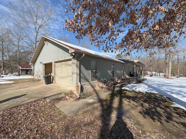 view of snow covered exterior with a garage