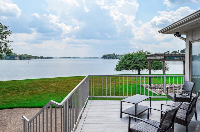 deck featuring a water view, a pergola, and a lawn