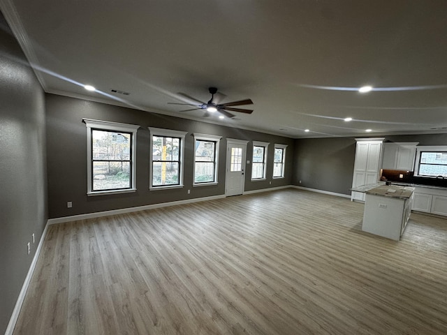 unfurnished living room featuring ceiling fan and light hardwood / wood-style floors