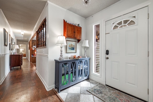 entryway with crown molding, hardwood / wood-style floors, and a textured ceiling