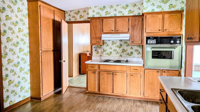 kitchen with white gas stovetop, sink, oven, and dark hardwood / wood-style flooring