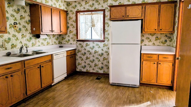 kitchen with white appliances, sink, and dark hardwood / wood-style floors