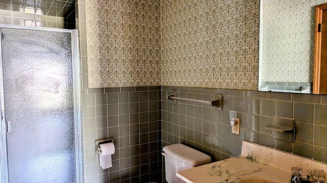 bathroom featuring vanity, tile walls, and toilet