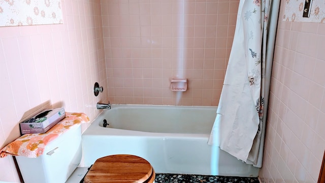 bathroom featuring tile walls and shower / bathtub combination with curtain