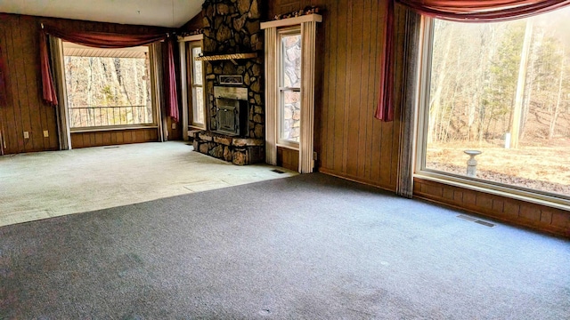 unfurnished living room featuring wood walls and carpet floors