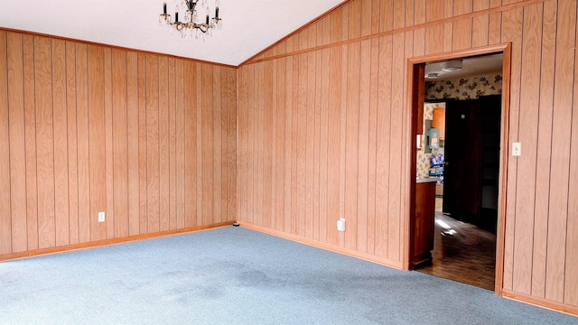 unfurnished room with lofted ceiling, wooden walls, carpet flooring, and a notable chandelier