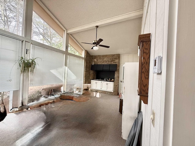 interior space with ceiling fan and vaulted ceiling with beams