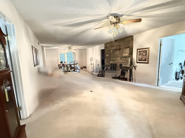 interior space with ceiling fan, a fireplace, and a textured ceiling