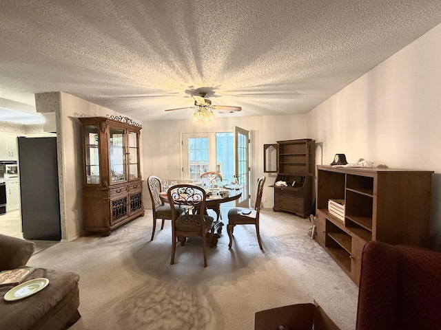 dining room with light carpet, a textured ceiling, and ceiling fan