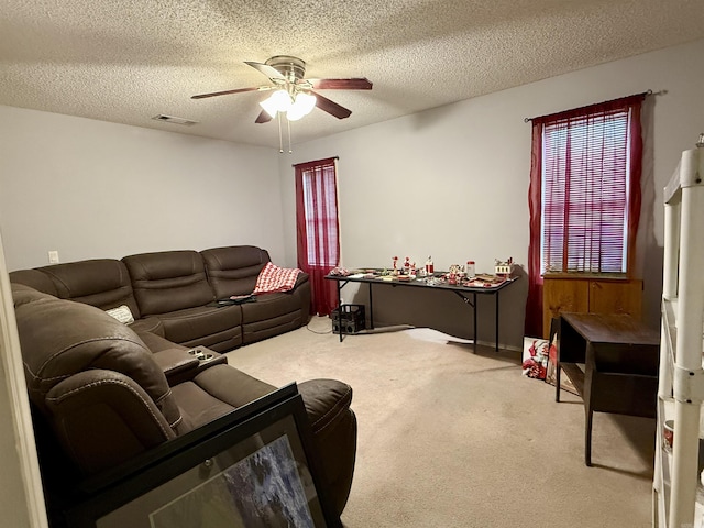 living room featuring carpet floors, a textured ceiling, and ceiling fan