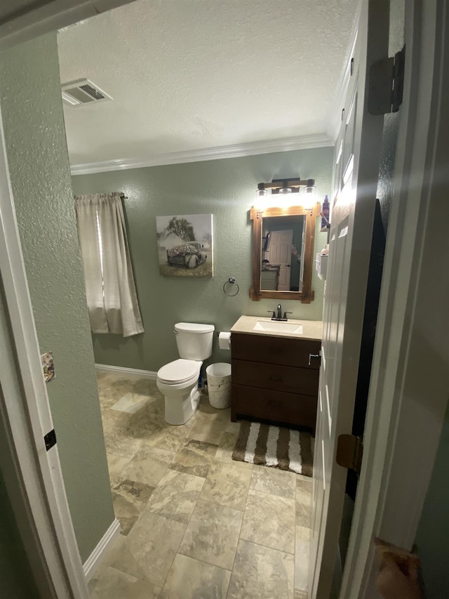 bathroom with ornamental molding, toilet, vanity, and a textured ceiling