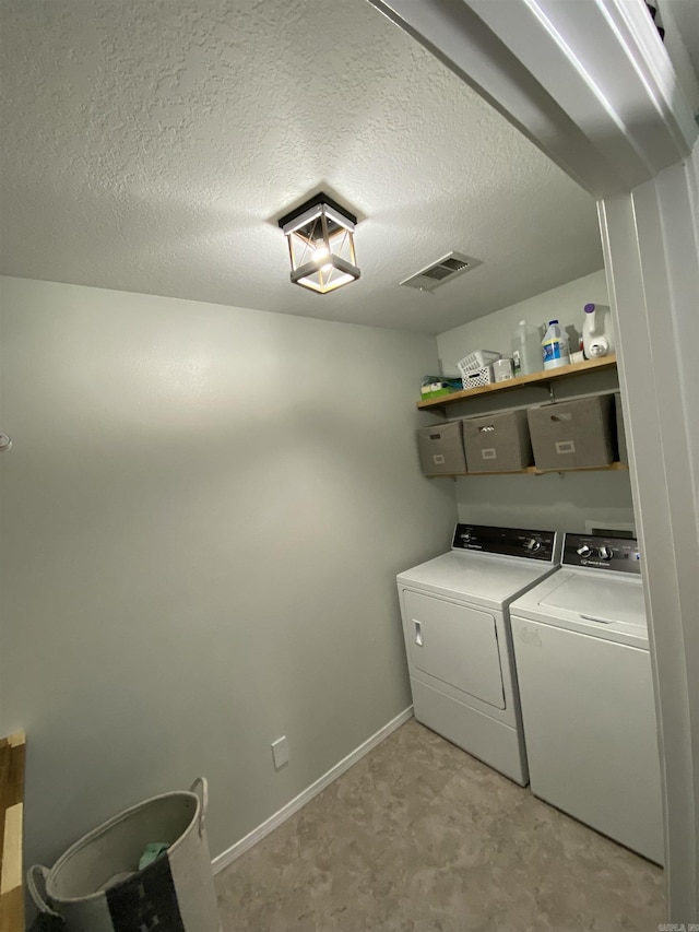 laundry area with a textured ceiling and independent washer and dryer