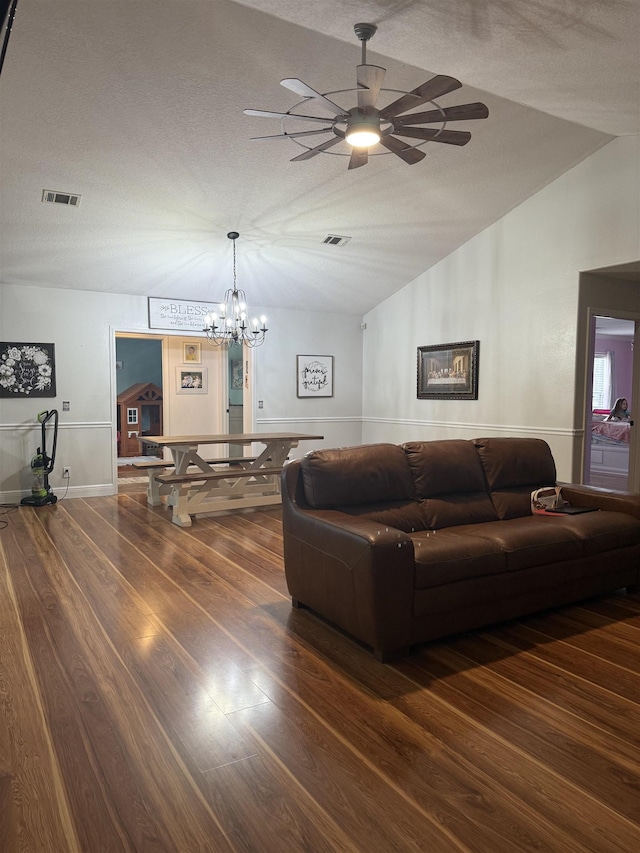 living room with dark hardwood / wood-style flooring, ceiling fan, vaulted ceiling, and a textured ceiling