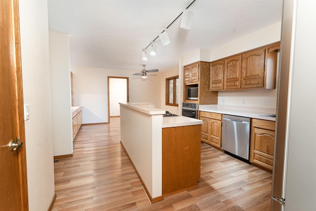 kitchen with dishwasher, a kitchen island, oven, and light hardwood / wood-style floors