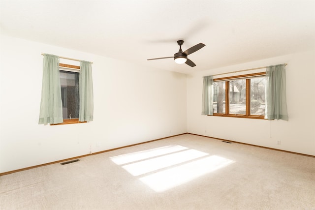 spare room with ceiling fan and carpet