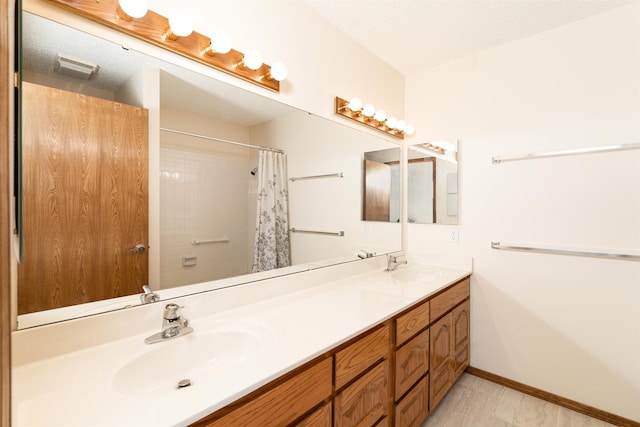 bathroom featuring a shower with curtain, vanity, and a textured ceiling