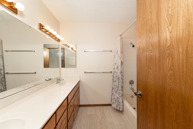 bathroom with vanity, hardwood / wood-style floors, shower / tub combo with curtain, and a textured ceiling